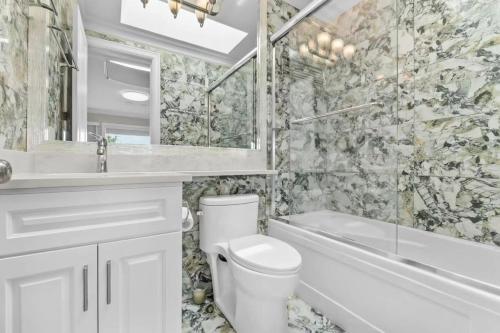 a bathroom with a toilet and a tub and a sink at 嘉博旅馆 Jiabo Hotel in Richmond