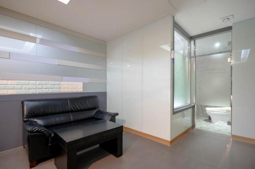 a black leather couch in a bathroom with a toilet at Nampo MGM Hotel in Busan