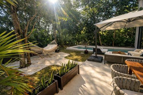 a patio with a hammock and a pool at Luxury Villa in Corasol 4BR Private Pool in Playa del Carmen
