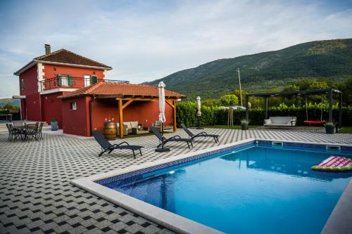 a house with a swimming pool in front of a house at Villa Rubin with heated pool in Slivno