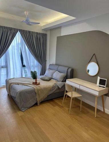 a bedroom with a bed and a table and a mirror at seroja hills condominium in Sepang