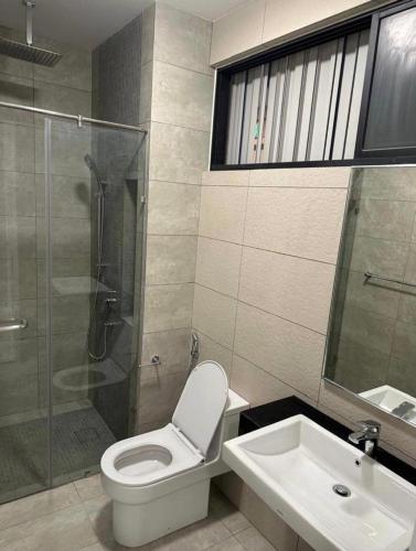 a bathroom with a toilet and a shower and a sink at seroja hills condominium in Sepang