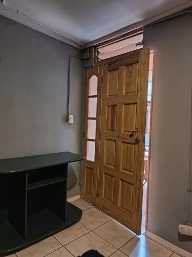 a room with a wooden door and a table at Casa Hostel Javi in Santiago