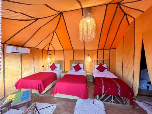 a room with two beds in a tent at Merzouga Infinity Dunes Camp in Merzouga