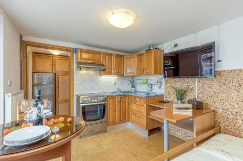a large kitchen with wooden cabinets and a table at River View Suite Mlinar Private Beach - Happy Rentals in Metlika