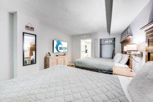 a large bedroom with a bed and a mirror at Oceanfront condo Heated Pools & Breathtaking View! in Myrtle Beach