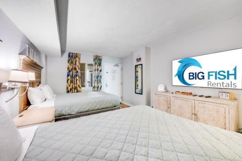 a large bedroom with a big fish sign on the wall at Oceanfront condo Heated Pools & Breathtaking View! in Myrtle Beach