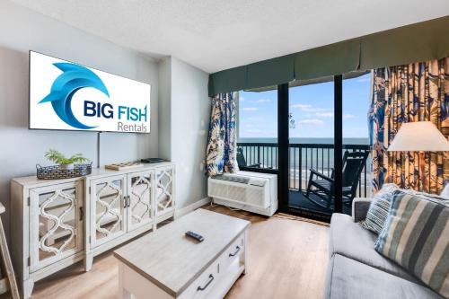 a living room with a big fish sign on the wall at Oceanfront condo Heated Pools & Breathtaking View! in Myrtle Beach