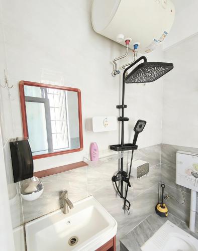 a bathroom with a sink and a mirror at 腾达公寓 in Wanning
