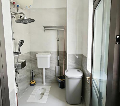 a small bathroom with a toilet and a shower at 腾达公寓 in Wanning