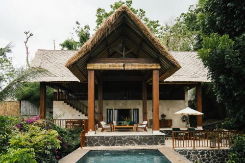 a house with a pool in front of it at Sanglung Villas & Suites in Kubutambahan
