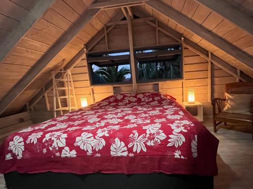 a bedroom with a red bed in an attic at Moorea Fare Korail in Temae