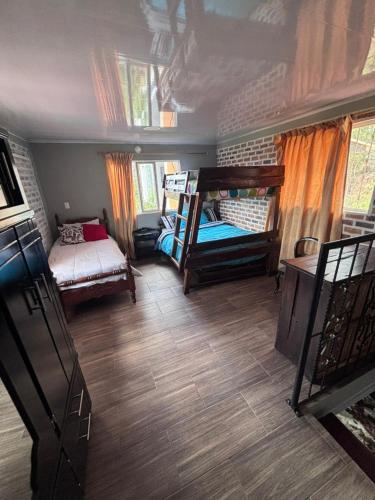 a bedroom with two bunk beds and a bed at Cabaña Belvedere in Duitama