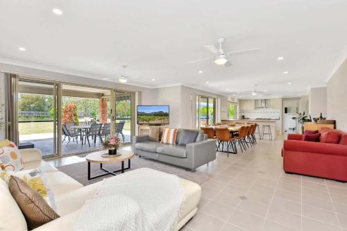 a living room with couches and a dining room at Marignano Homestead in Broke