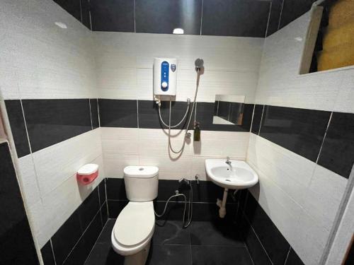 a bathroom with a toilet and a sink at Kemas Homestay in Johor Bahru
