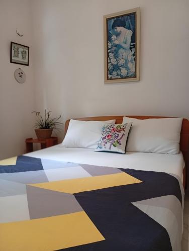 a bedroom with a bed with a colorful blanket on it at Tiny Art House with Garden in Godagama