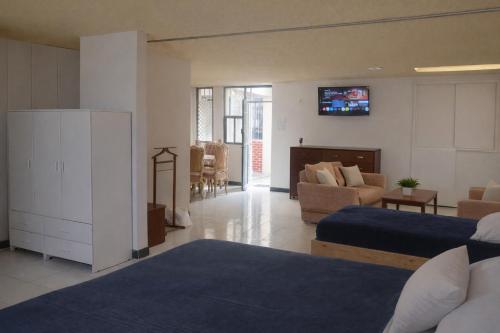 a bedroom with two beds and a living room at Hospedaje Villa Posadas in Momoxpan