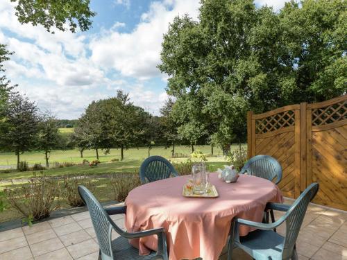 une table avec un tissu de table rose sur une terrasse dans l'établissement Holiday Home in Bonnemain near Mont St-Michel, à Bonnemain