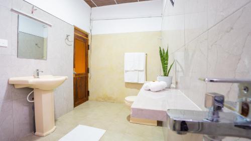a bathroom with a sink and a toilet and a shower at La Roche Hotel Sigiriya in Sigiriya