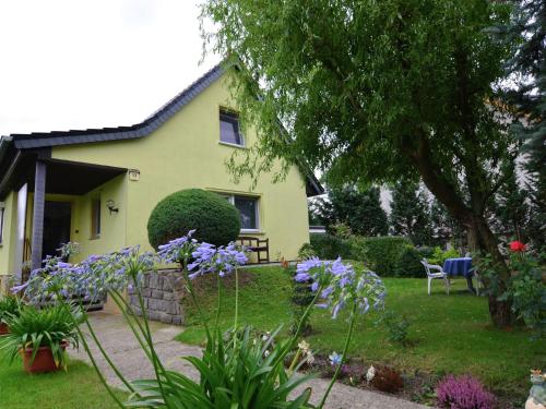 SchmogrowにあるQuaint Holiday Home in Schmogrow Fehrowの紫花の黄色い家