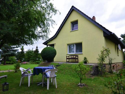 a house with a table and chairs in front of it at Quaint Holiday Home in Schmogrow Fehrow in Schmogrow