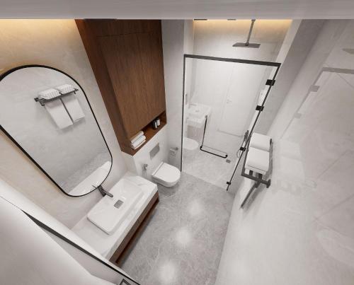 a bathroom with a mirror and a sink and a toilet at Sangkahak Mith Hotel in Kep