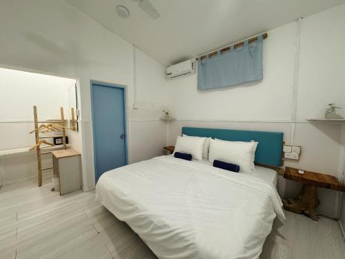 a bedroom with a large white bed with a blue door at Thulusdhoo Garden Villa in Thulusdhoo