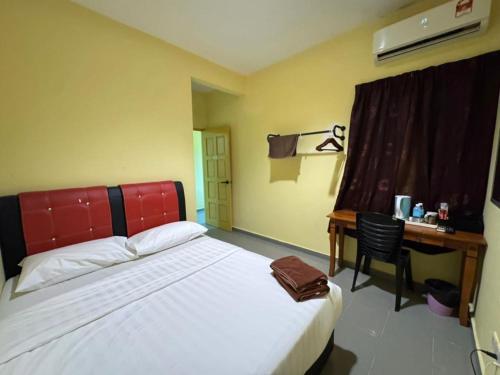 a bedroom with a bed and a desk with a desk at Kemas Homestay in Johor Bahru