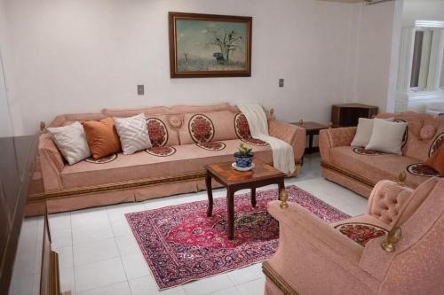 a living room with two couches and a table at Hospedaje Villa Posadas in Momoxpan