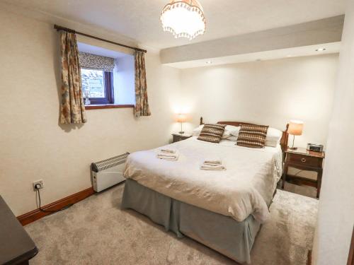 a bedroom with a large bed and a window at Ghyll Bank Bungalow in Staveley