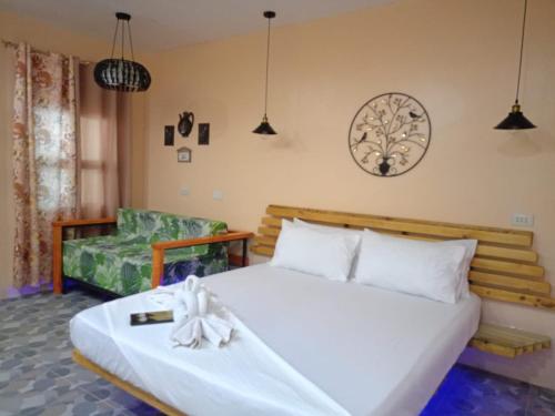 a bedroom with a large bed and a couch at Datoni Italian Restaurant in Tabigue