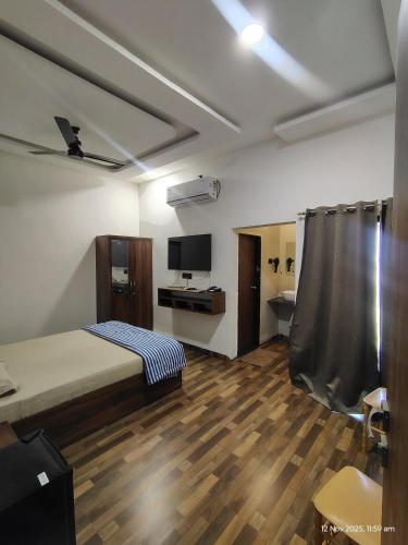 a bedroom with a bed and a desk and a television at Hotel Jatra in Sillod