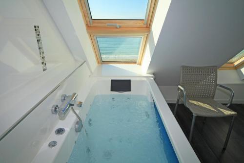 y baño con bañera y ventana. en Villa de la plage de Plouescat, en Plouescat