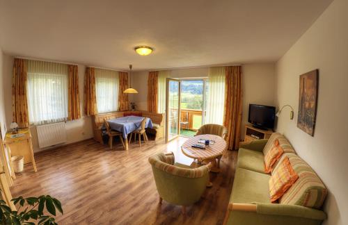 a living room with a couch and a table at Sonnleiten - Guggerhof - Villa Sonnenwies in Tannheim