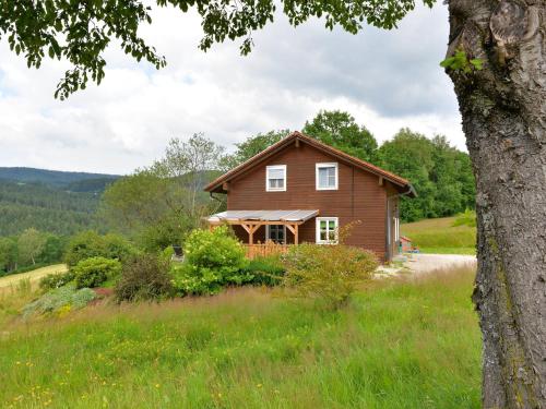 a house on a hill with a tree at holiday house in the Bavarian Forest in Drachselsried