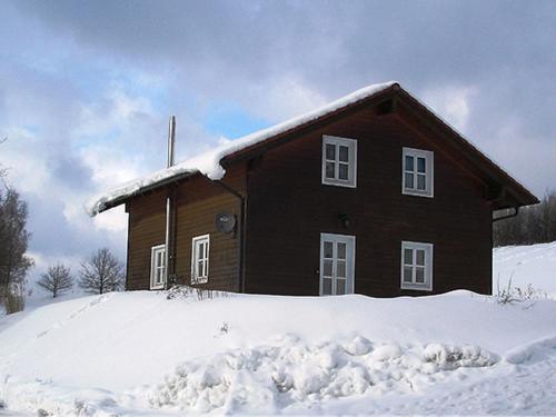 uma casa coberta de neve com neve à sua volta em holiday house in the Bavarian Forest em Drachselsried