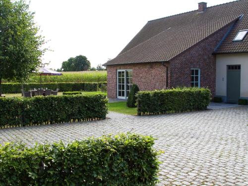 a brick house with hedges in front of a yard at This spacious holiday home in the smallest details in Peer