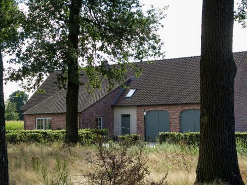 a red brick house with two garage doors at This spacious holiday home in the smallest details in Peer