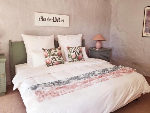a bedroom with a large white bed with pillows at Schalkenbosch Farm Cottages in Tulbagh