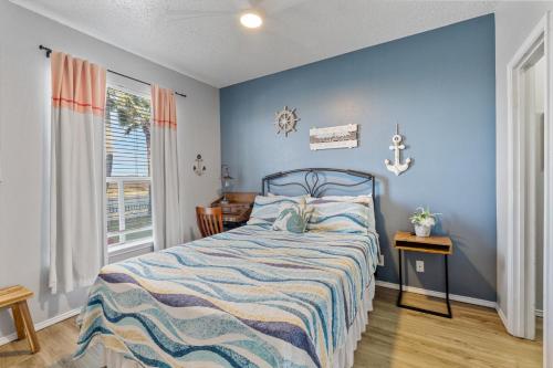 a bedroom with a bed with a blue wall at Island Palms - 2 min walk to the Beach in Corpus Christi