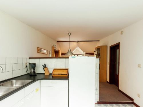 a kitchen with white cabinets and a sink at Peaceful Nature Stay in Bohon in Barvaux