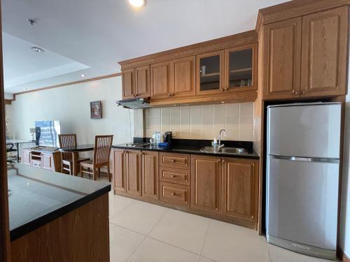 a kitchen with wooden cabinets and a stainless steel refrigerator at View Talay 6 by Pat 42 in Pattaya