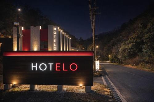a sign for a hotel on the side of a road at HOTELO OTONA no ASOBIBA in Yosano