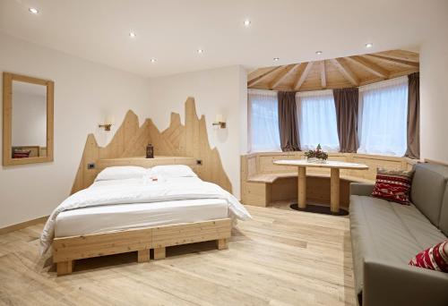 a bedroom with a large bed and a couch at B&B Augusto in Madonna di Campiglio
