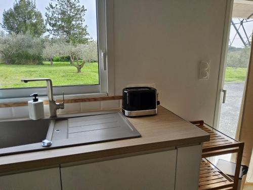 a kitchen counter with a sink and a window at Chez Lucia petite maison a la campagne pour 4 pers ,parking prive in Istres