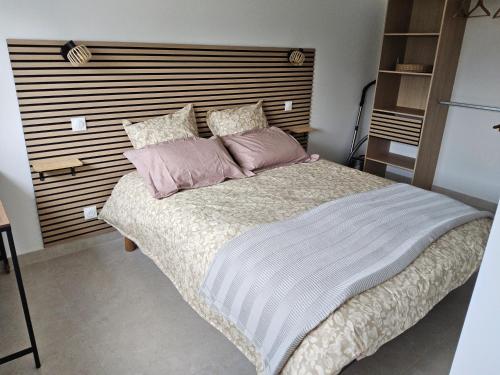 a bedroom with a large bed with pink pillows at Chez Lucia petite maison a la campagne pour 4 pers ,parking prive in Istres