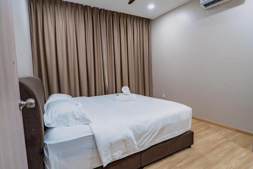 a bedroom with a bed with white sheets and a window at KT Seaview City Suite in Kuala Terengganu
