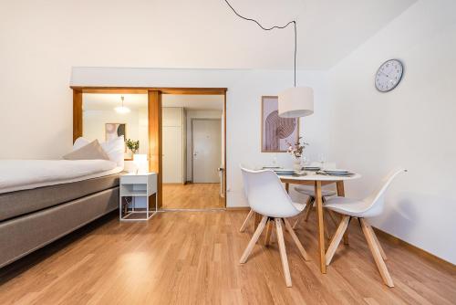 a bedroom with a bed and a table and chairs at SOHO A !Gratis parken, Free Parking! in Kreuzlingen