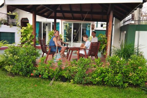 a group of people sitting at a table on a patio at Romeo and Juliet Guest House in Negombo