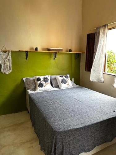 a bedroom with a bed with a green wall at Casa Esmeralda in Lençóis